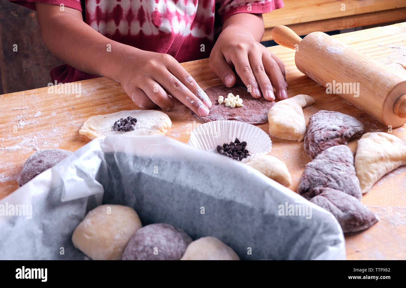 Cropped hands of boy preparing food on kitchen island Stock Photo