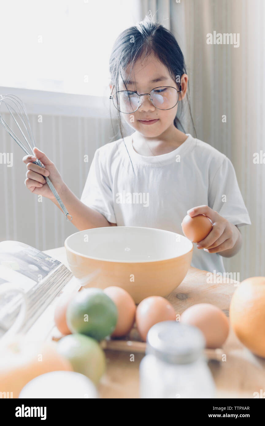 Girl preparing food while standing in kitchen at home Stock Photo