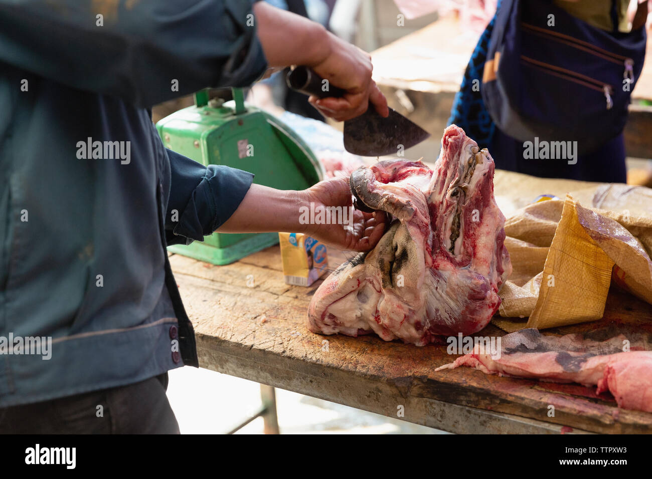 Butcher cutting pig head at market, Bac Ha, Lao Cai Province, Vietnam, Asia, Stock Photo