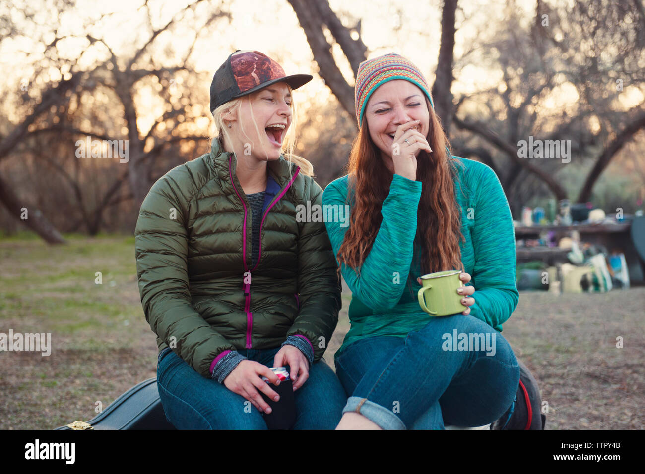 Cheerful female friends enjoying at camp site Stock Photo