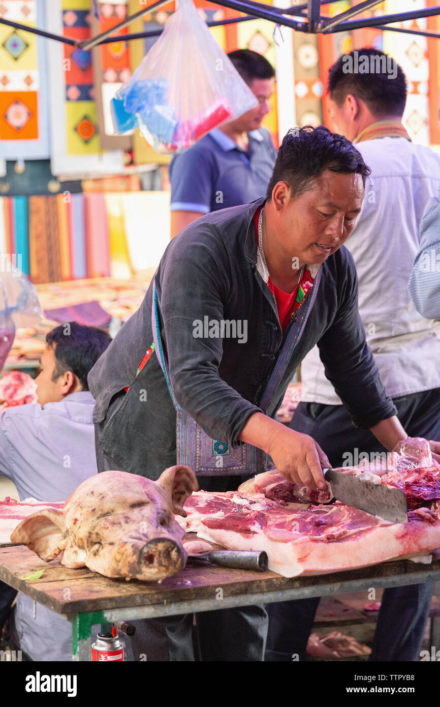 Butcher cutting raw meat at market, Bac Ha, Lao Cai Province, Vietnam, Asia, Stock Photo