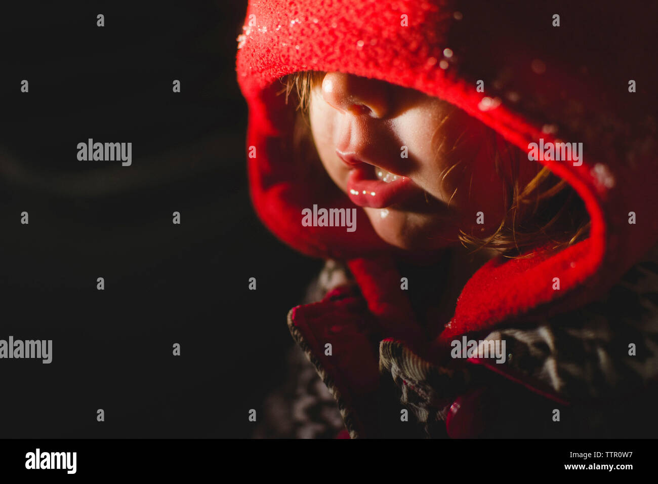 Close-up of girl wearing hood clothing in dark room Stock Photo