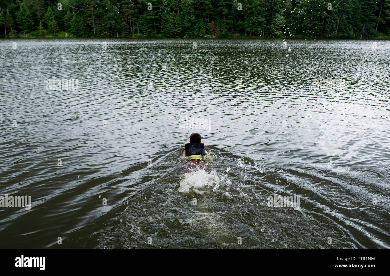 Rear view of boy swimming in lake Stock Photo