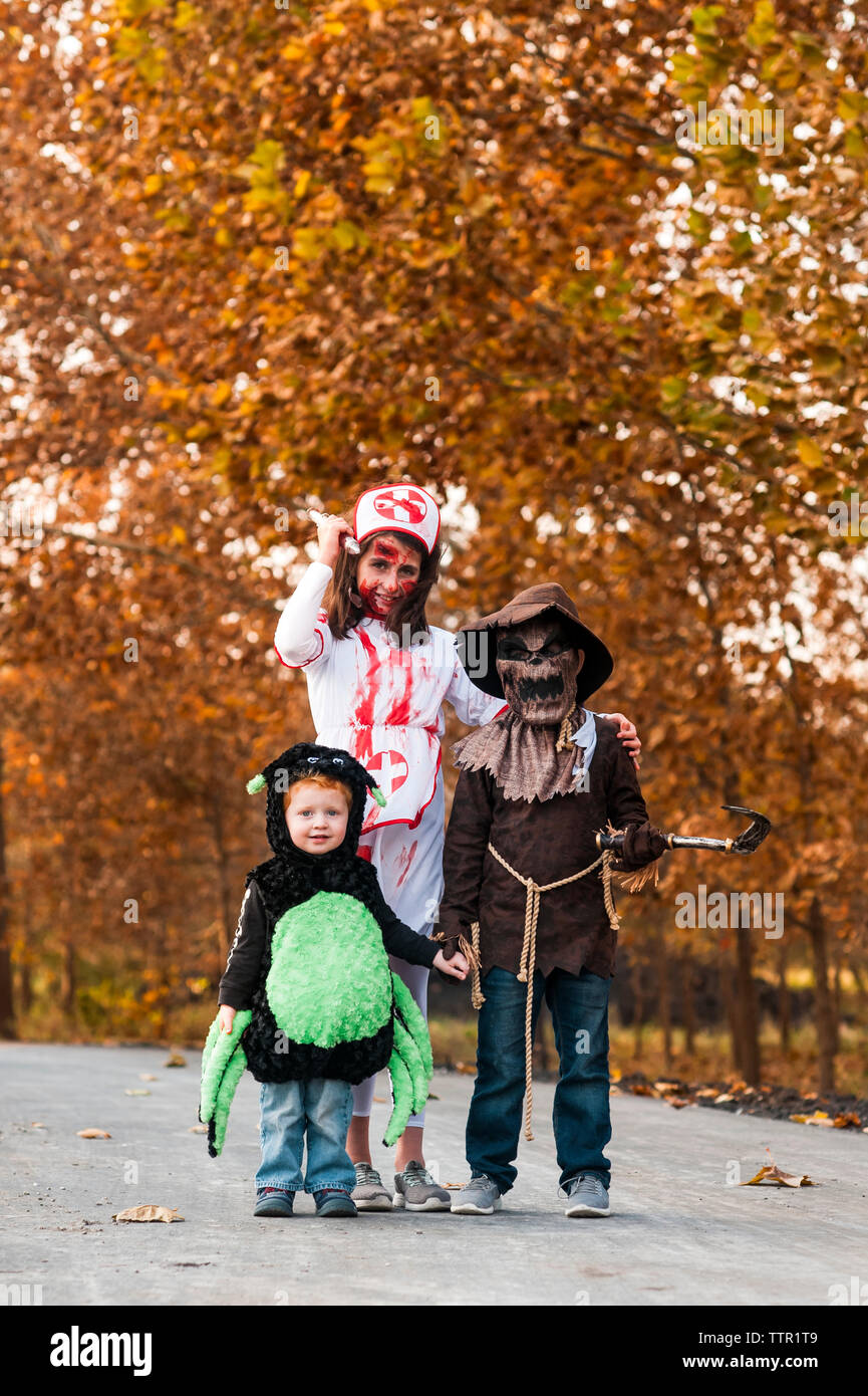 siblings dressed up in halloween costumes ready for trick or treating Stock Photo