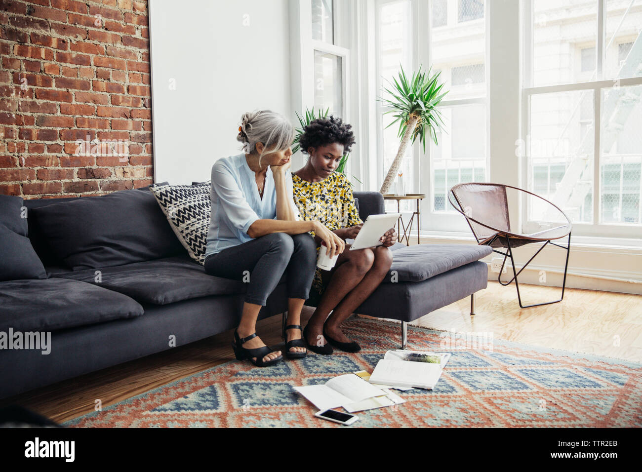 businesswomen using tablet computer on sofa in creative office Stock Photo