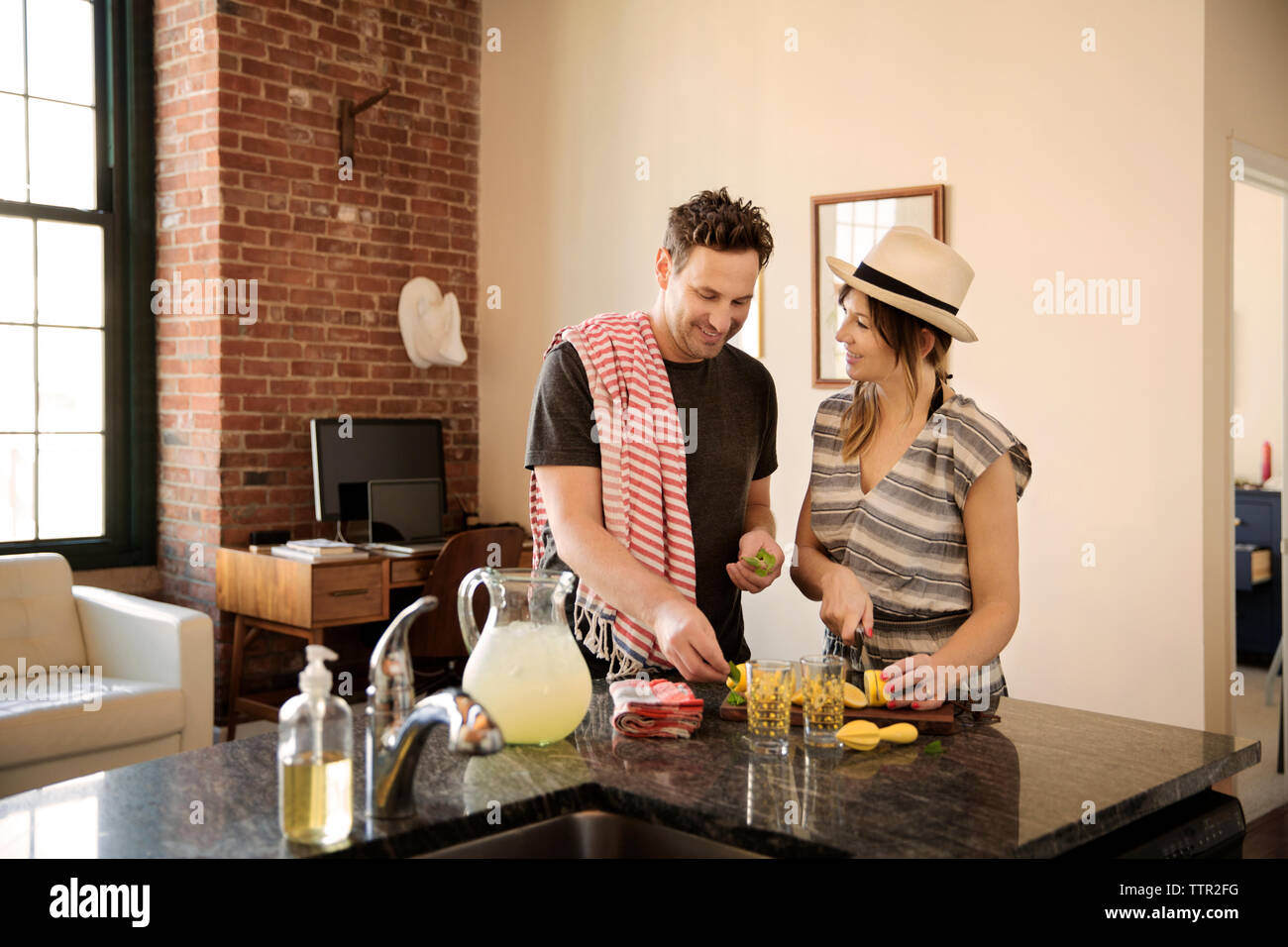 Happy couple preparing food in kitchen Stock Photo