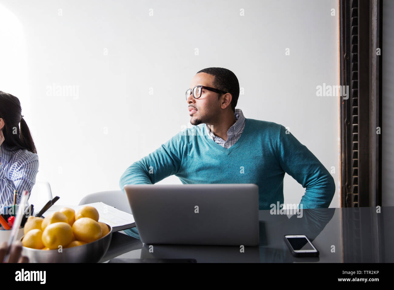 Businessman with laptop concentrating in meeting at office Stock Photo