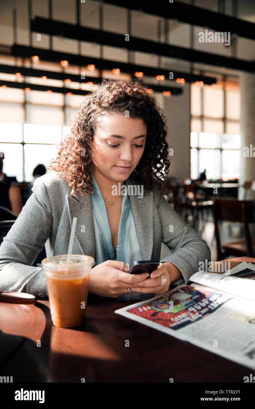 businesswoman using smart phone at cafe table Stock Photo