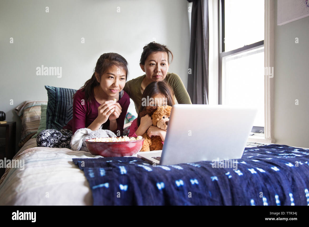 Family watching movie in laptop on bed Stock Photo