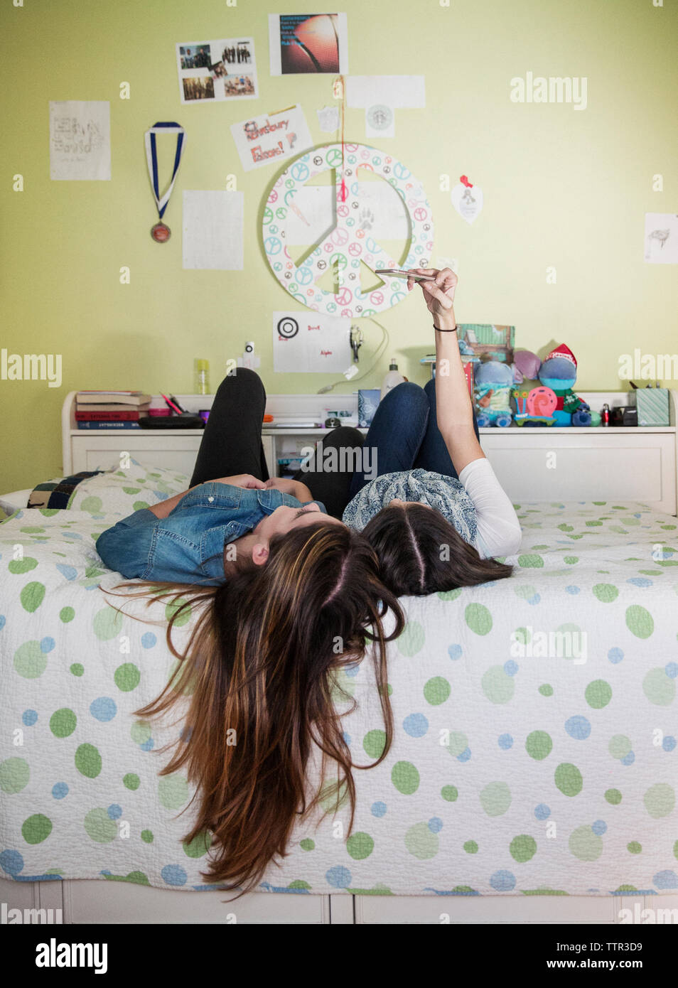 Siblings taking selfie while lying on bed at home Stock Photo