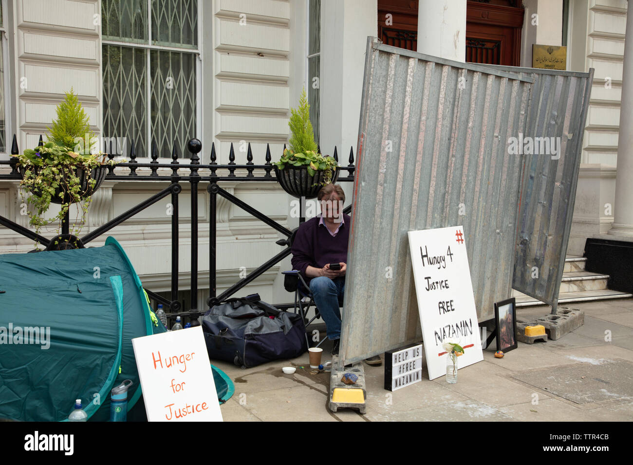 London, UK. 17th June 2019. Hunger striker Richard Ratcliffe behind an iron board, placed there by Iranian embassy staff and builders, in front of the Iranian embassy in London protesting the detention of his wife Nazanin Zaghari in Iran over spying allegations. Credit: Joe Kuis / Alamy Stock Photo