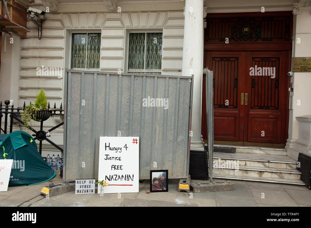 London, UK. 17th June 2019. Tent of Richard Ratcliffe on hunger strike in front of the Iranian embassy in London in protest of the detention of his wife Nazanin Zaghari in Iran over spying allegations. Staff of the embassy and builders have placed iron boards squeezing the protesters' space. Credit: Joe Kuis / Alamy Stock Photo