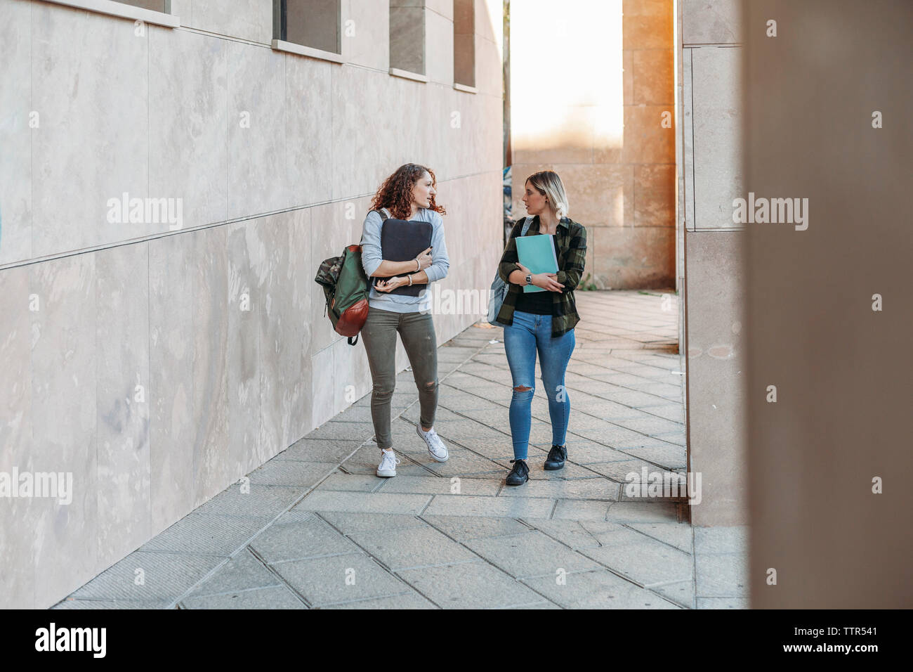 Two young students walking together in the college Stock Photo