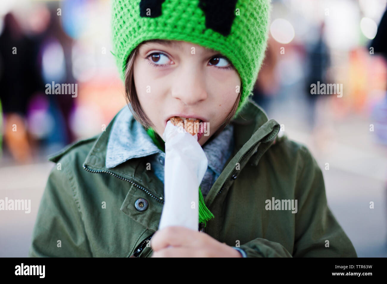 Close-up of boy eating churro at amusement park Stock Photo