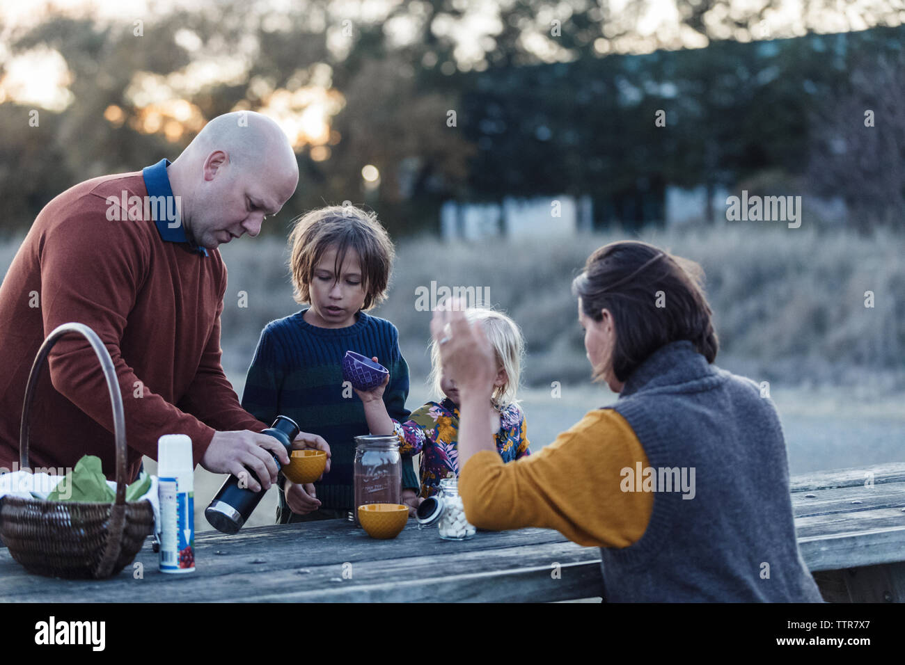 Family setting picnic table with hot chocolate during fall Stock Photo