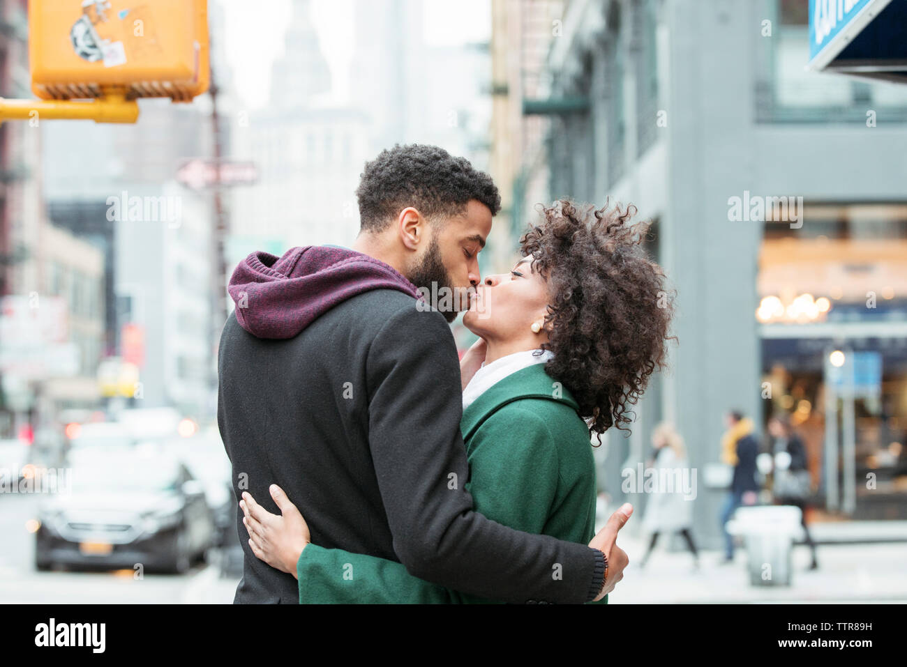 Couple kissing on city street Stock Photo