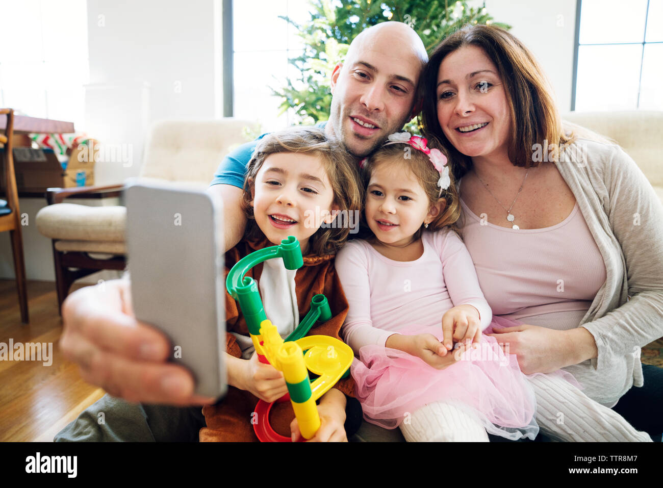 Smiling family taking selfie at home Stock Photo