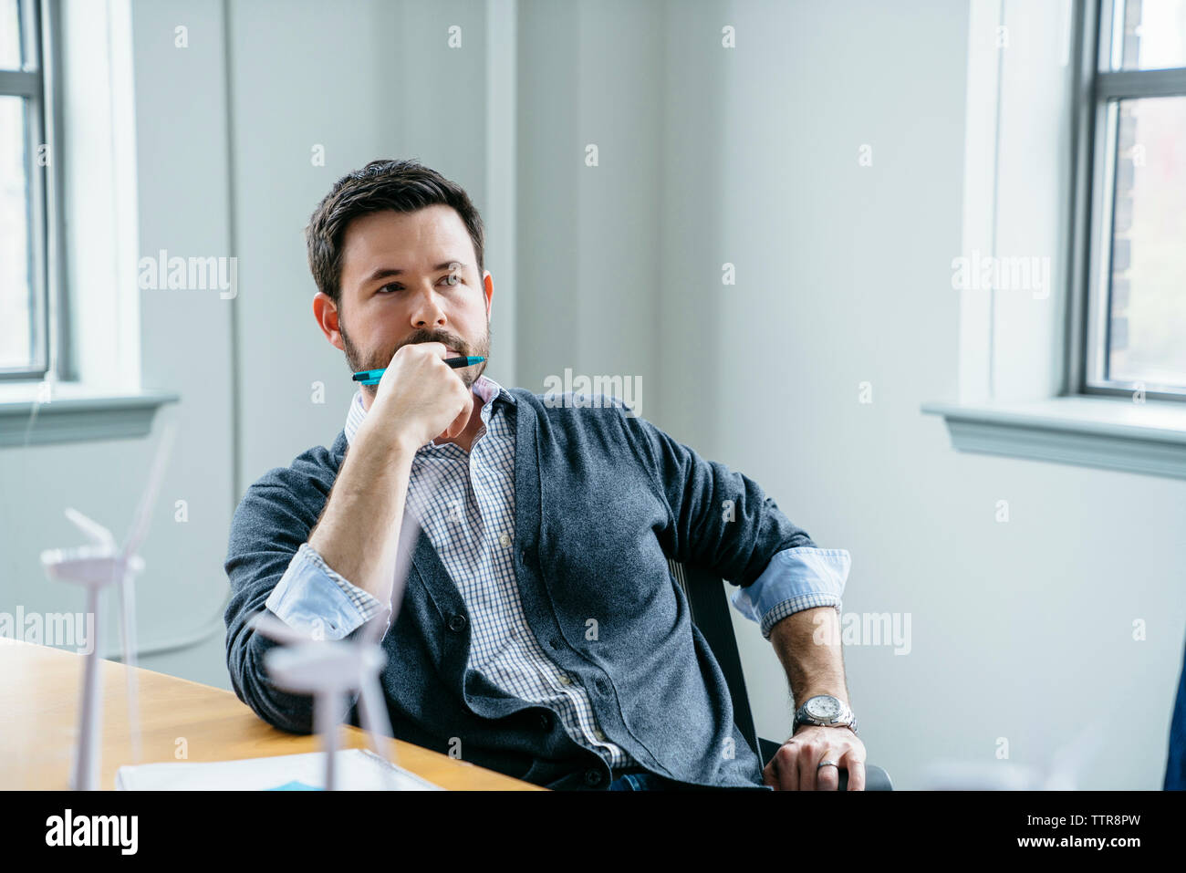 Thoughtful businessman sitting on chair in office Stock Photo