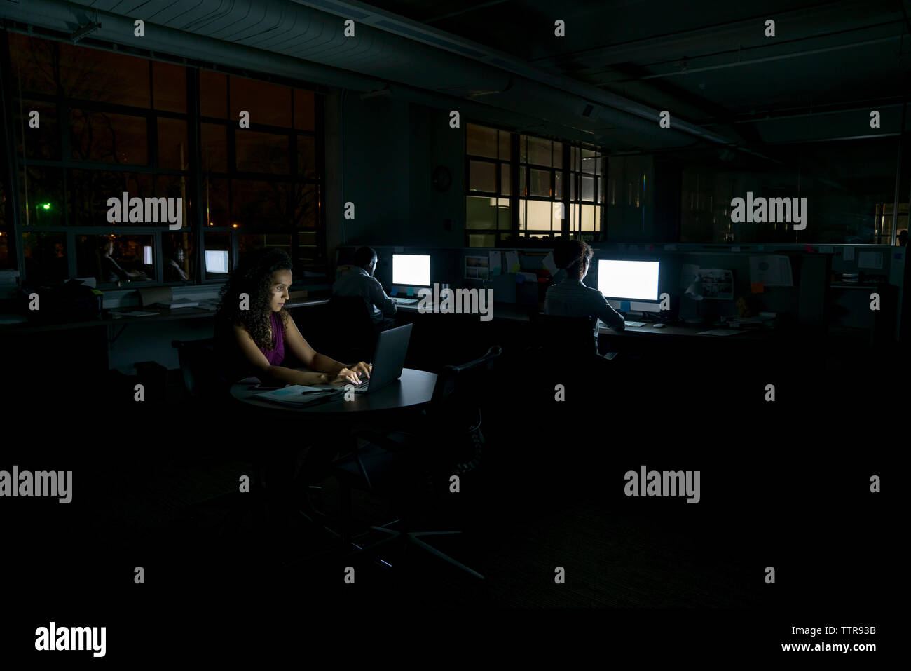 business people working in dark office at night Stock Photo