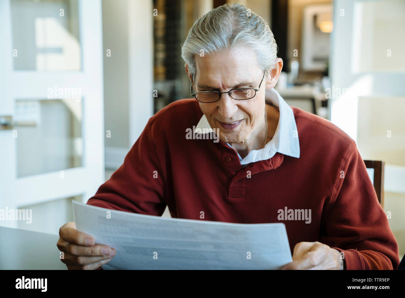 Senior man reading documents in financial advisor's office Stock Photo