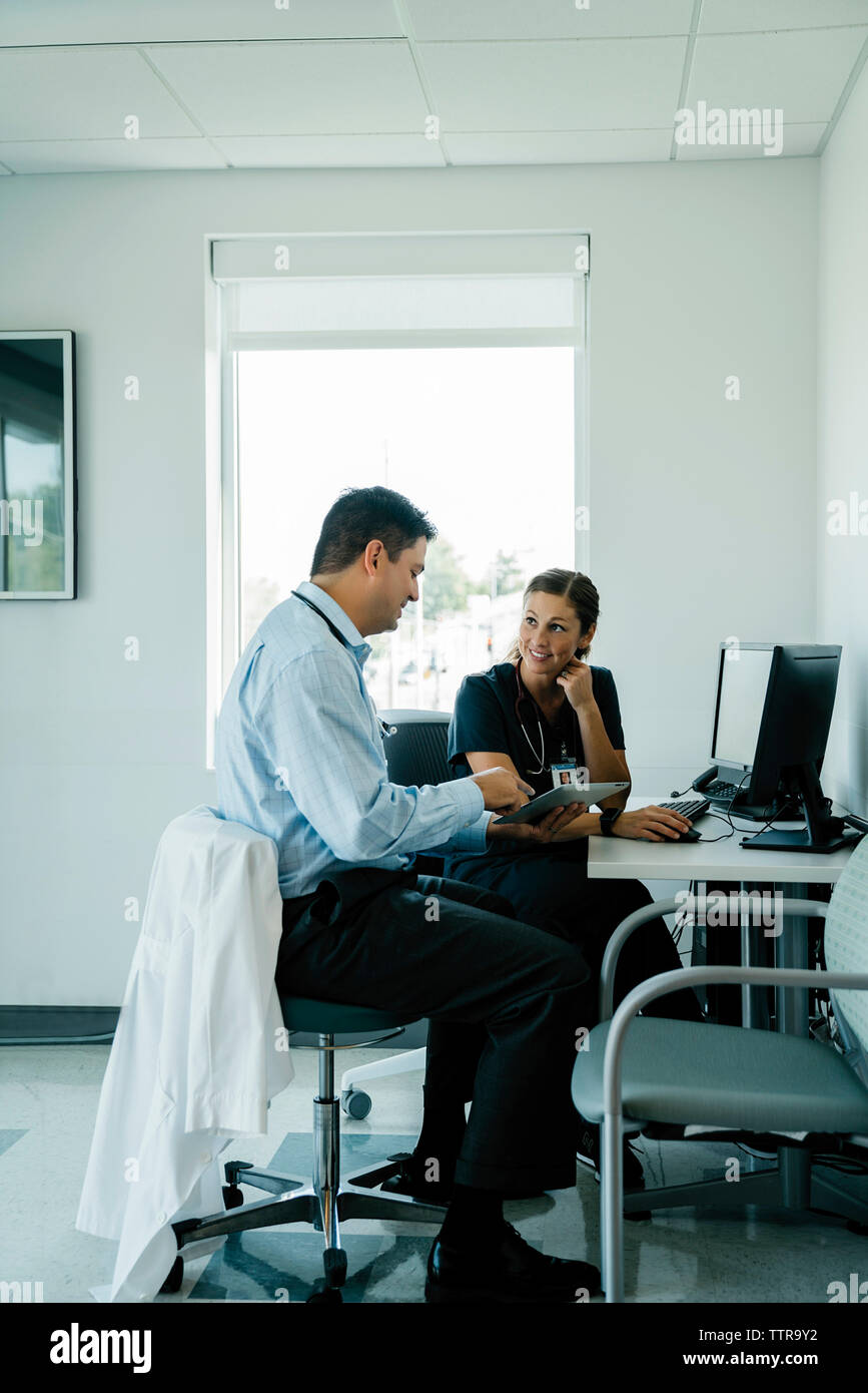 Doctors discussing over tablet computer in hospital Stock Photo