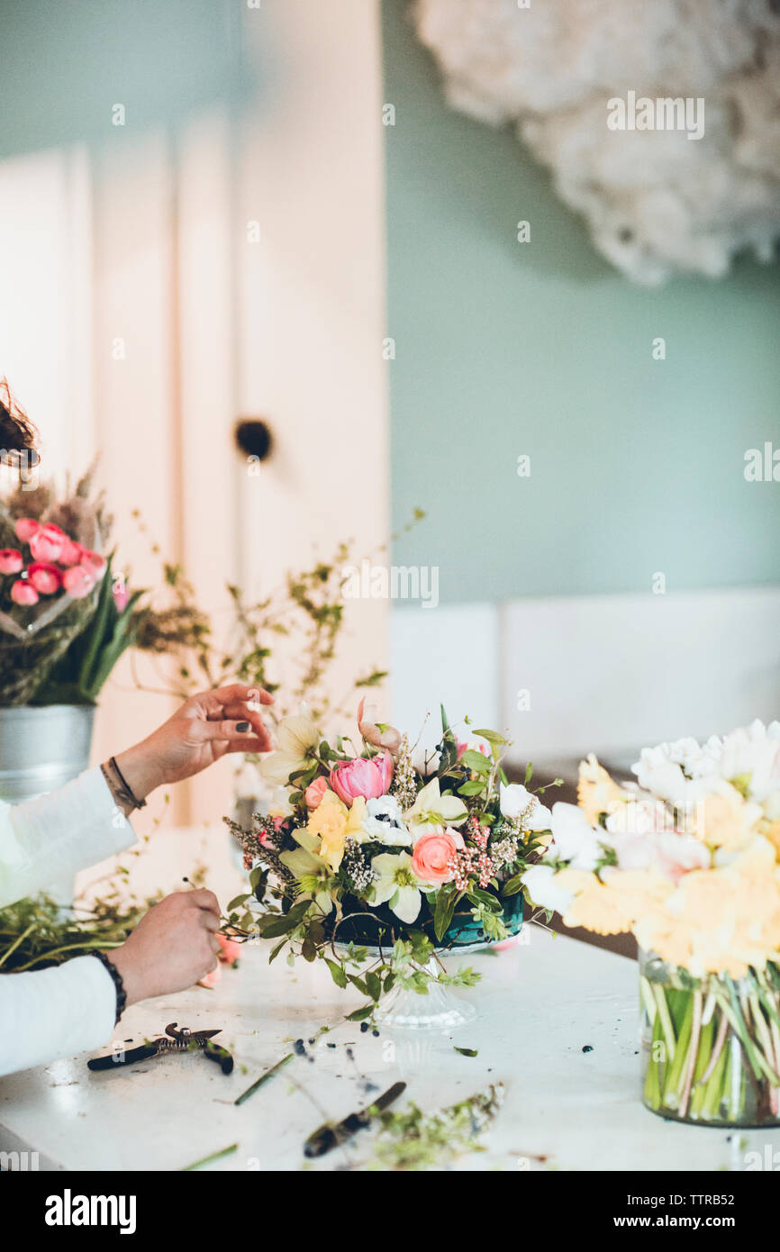 Cropped hands of florist arranging flowers at store Stock Photo
