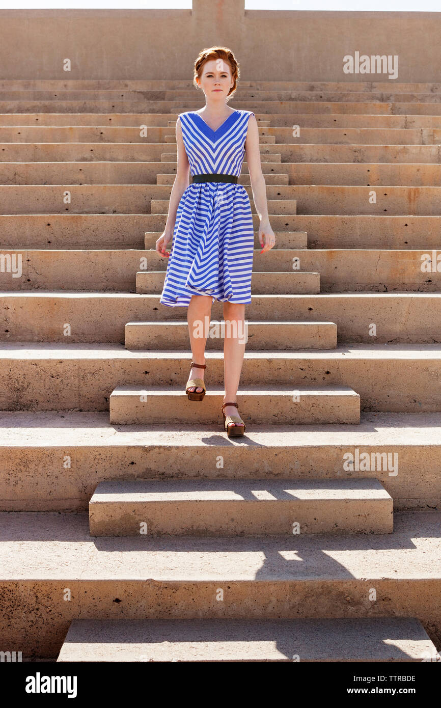 Full length of beautiful woman moving down steps Stock Photo