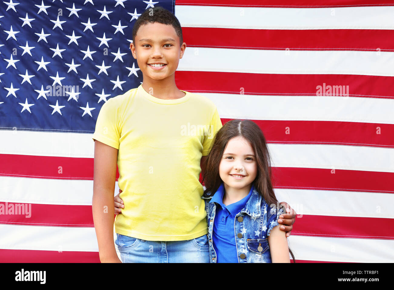 Boy and girl on American flag background Stock Photo - Alamy