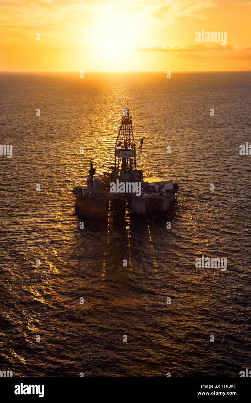 High angle view of oil platform in sea during sunset Stock Photo