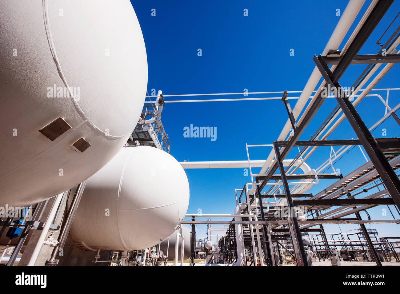 Natural gas tanks in oil refinery against clear sky Stock Photo