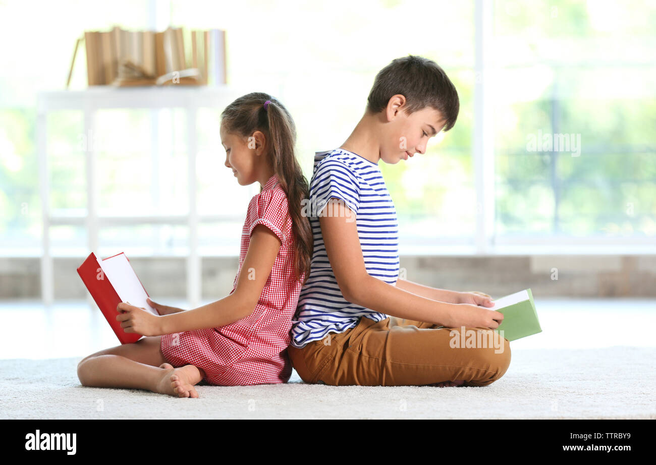 Cute boy and girl reading books at home Stock Photo - Alamy
