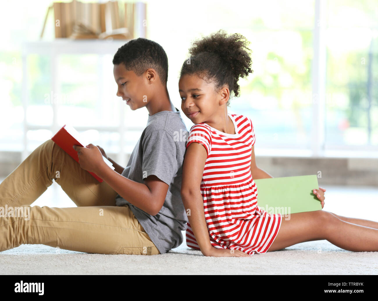 Cute boy and girl reading books at home Stock Photo - Alamy