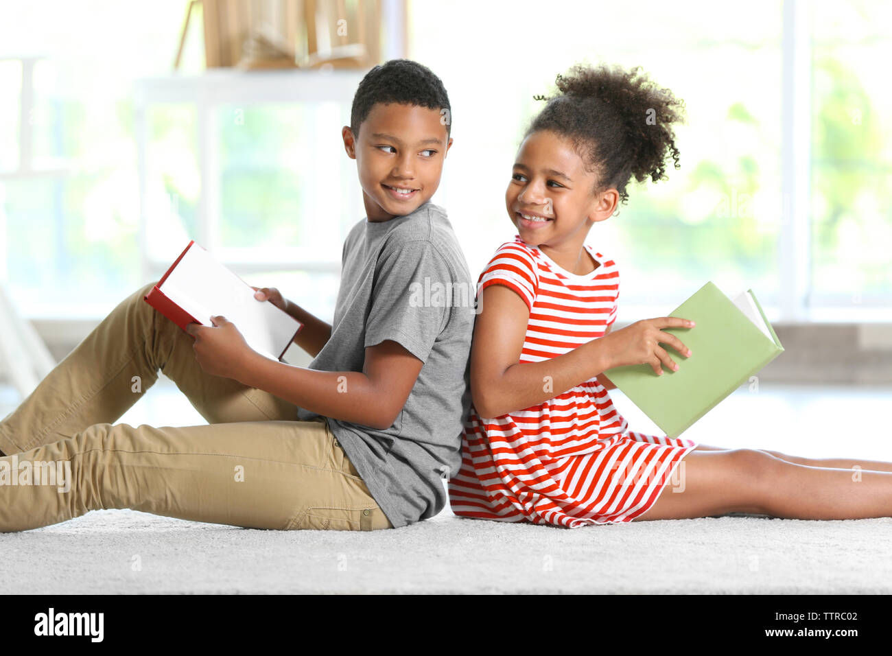 Cute boy and girl reading books at home Stock Photo - Alamy