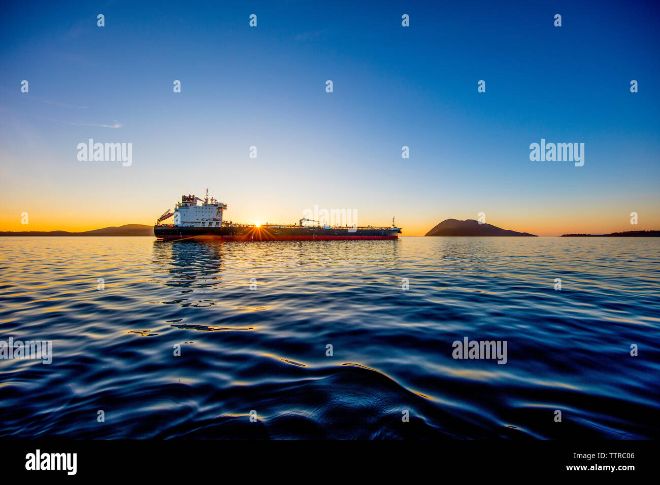 Ship in sea against blue sky during sunset Stock Photo