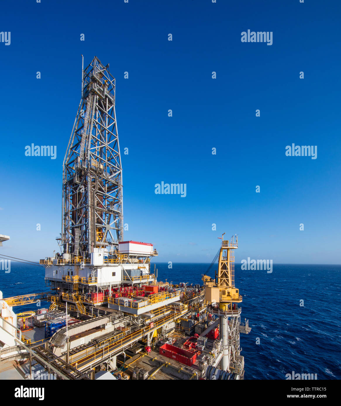 Drill ship in sea against clear blue sky Stock Photo