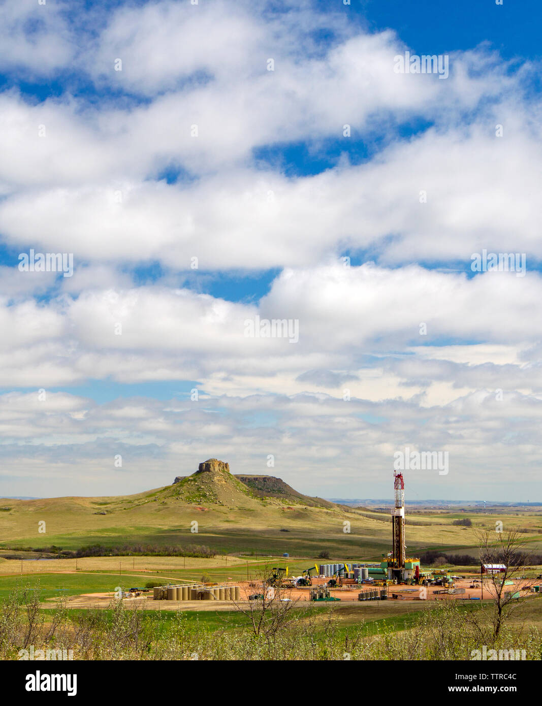 Oil production platform on field against cloudy sky Stock Photo