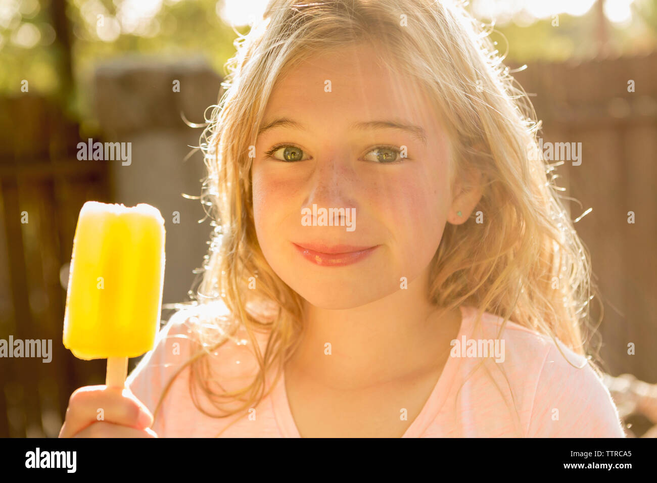 Portrait of girl holding popsicle at backyard Stock Photo