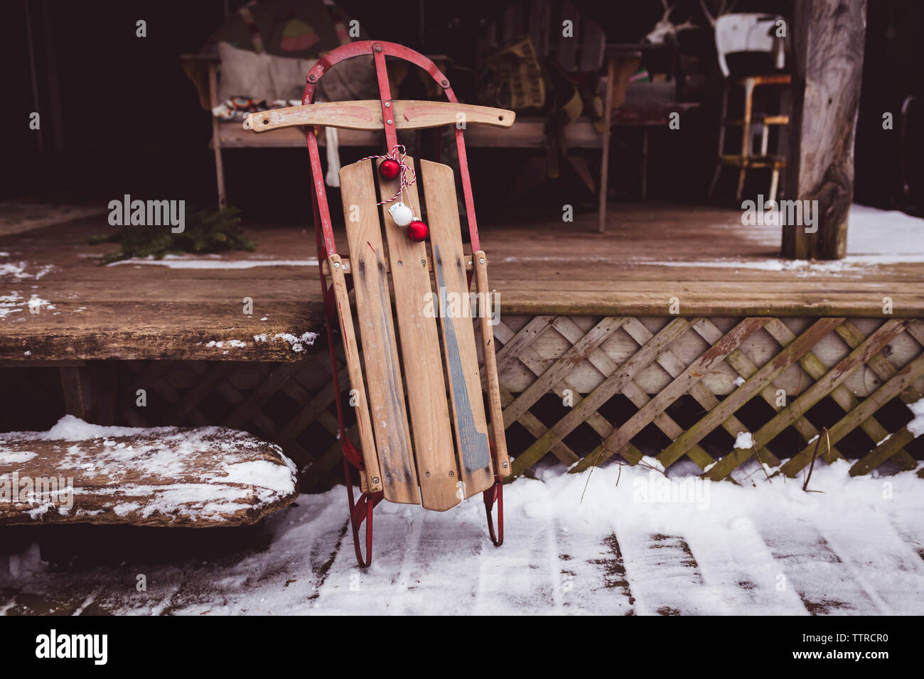 Wooden sledge with baubles on porch during christmas Stock Photo