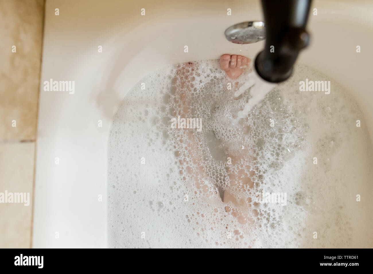 Low section of boy in bath tub Stock Photo