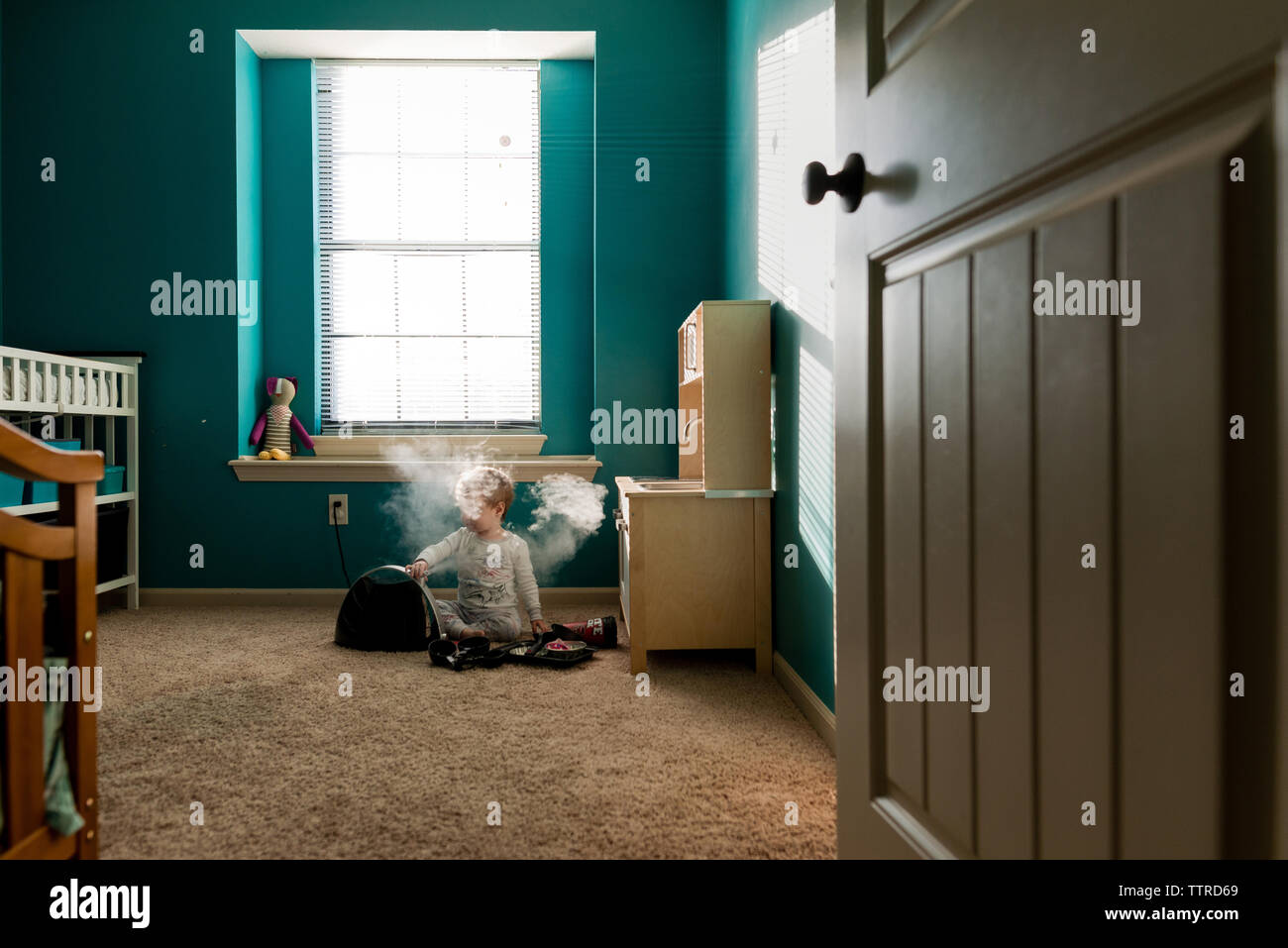 Boy playing with steam machine while sitting on rug at home Stock Photo