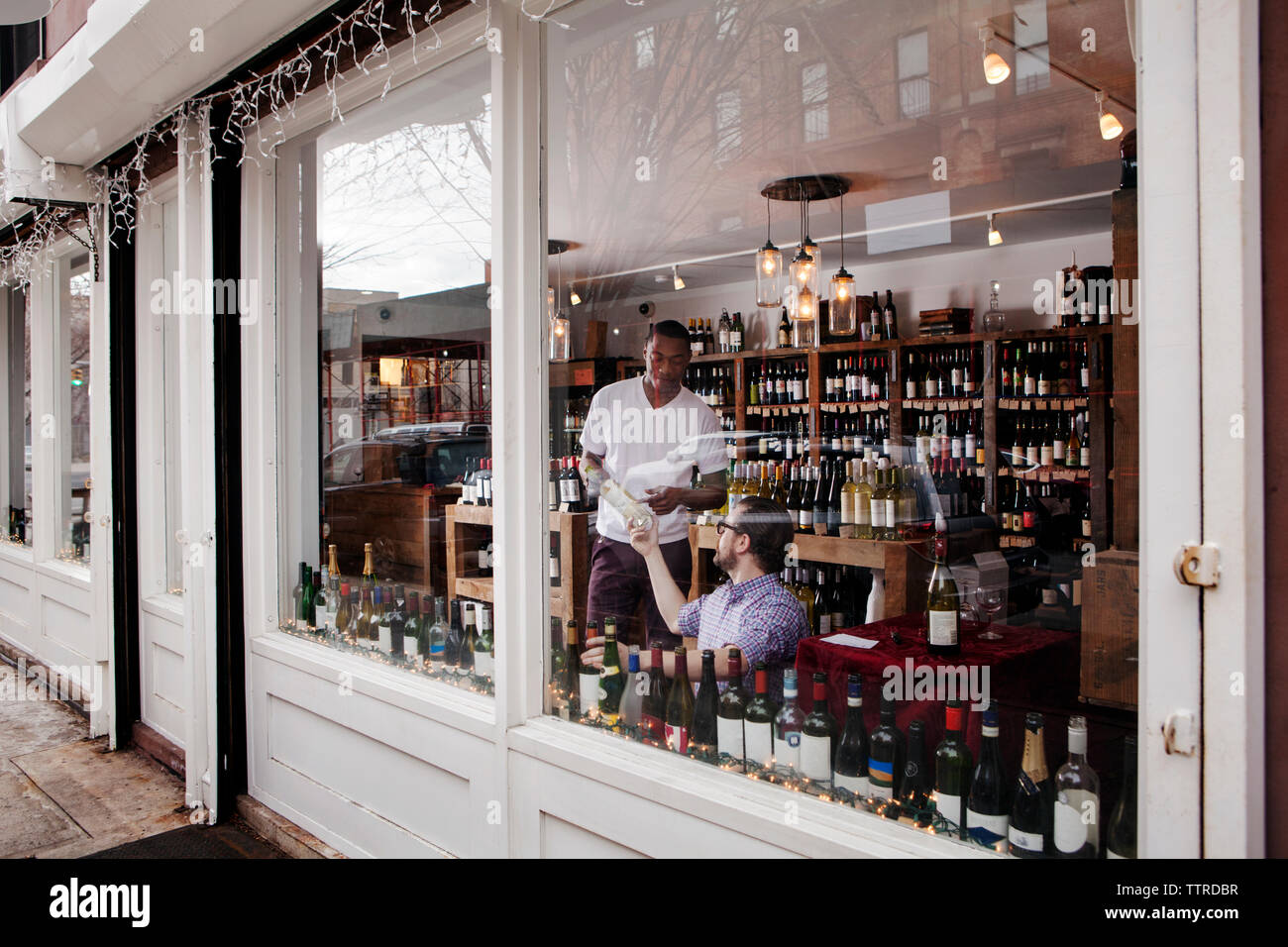 Multi-ethnic colleagues working in wine shop Stock Photo