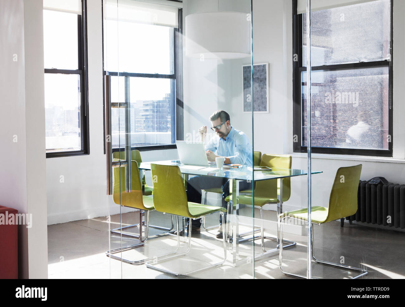 Creative businessman using laptop in board room Stock Photo