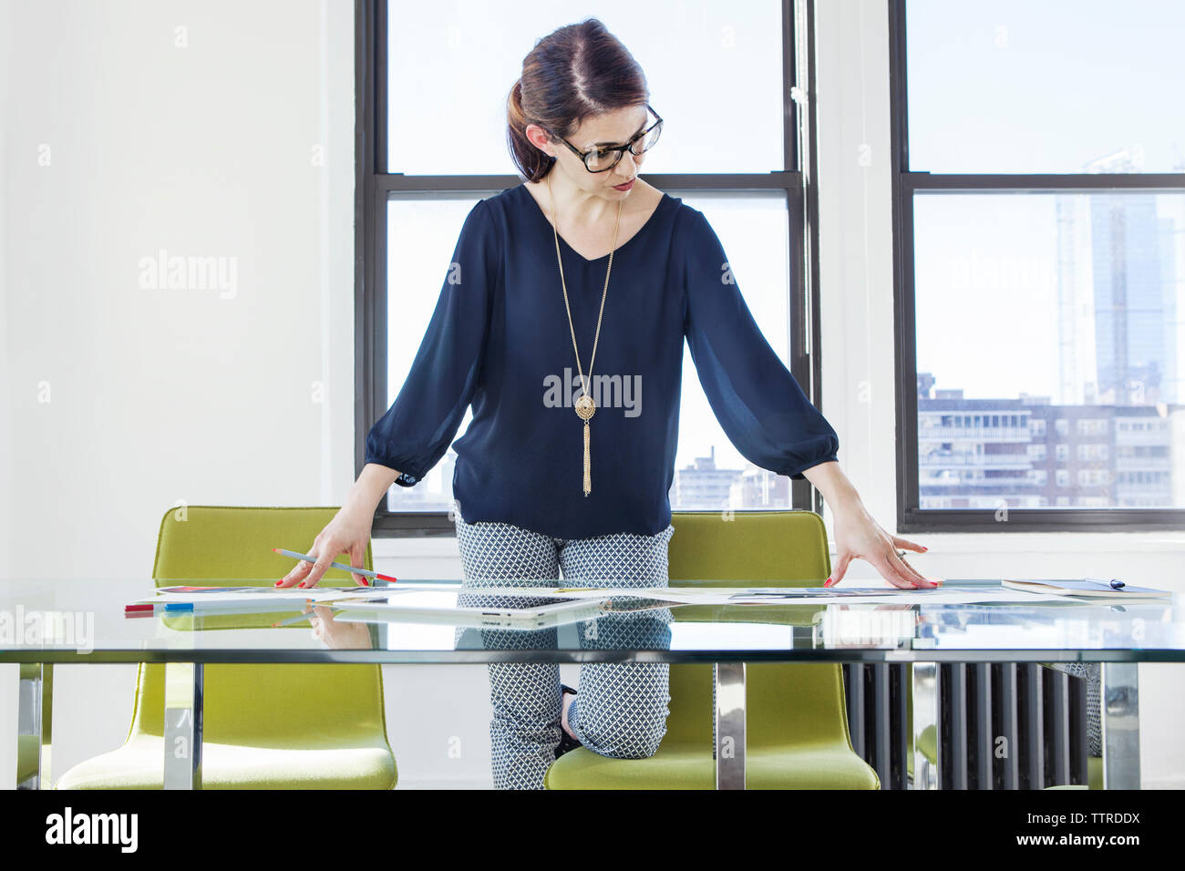 businesswoman examining photographs at conference table Stock Photo