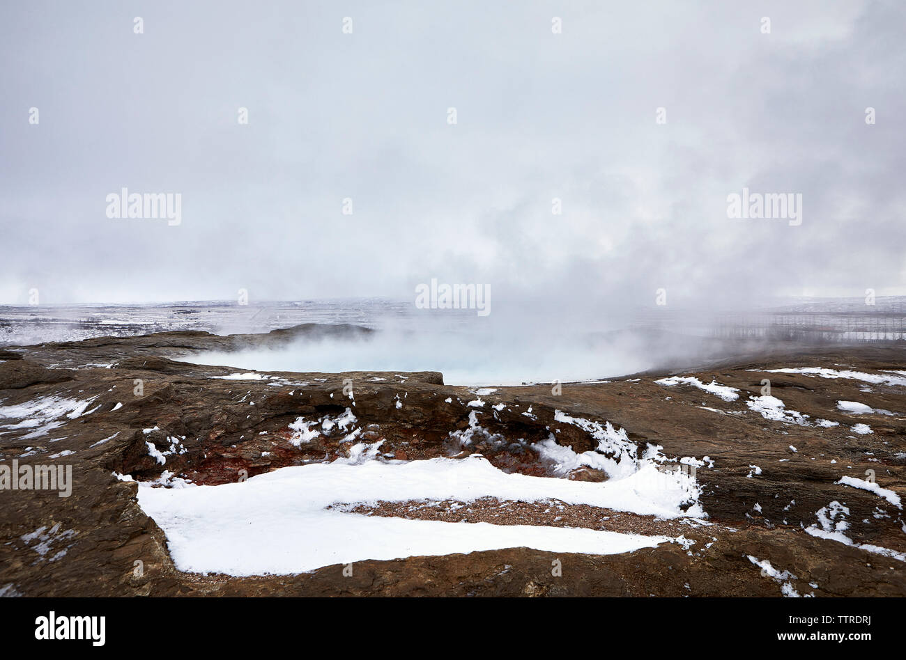 Steam emitting from geyser against sky during winter Stock Photo