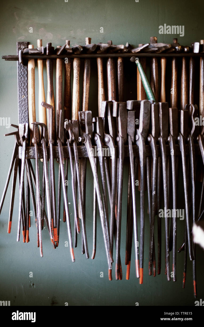 Pliers and hammers arranged on rack Stock Photo