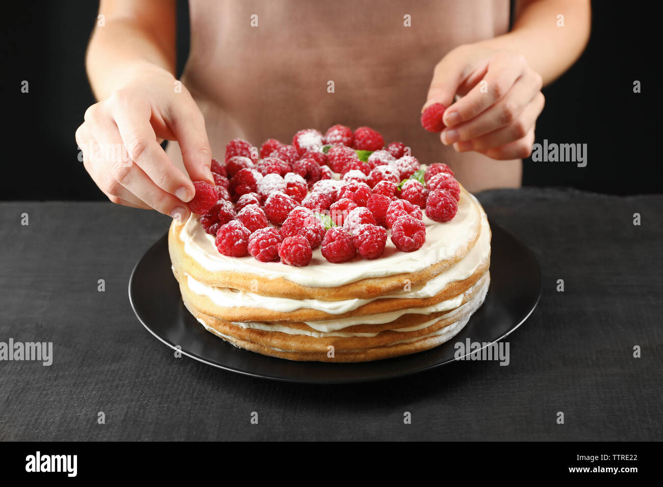 Woman decorating tasty raspberry hi-res stock photography and images ...