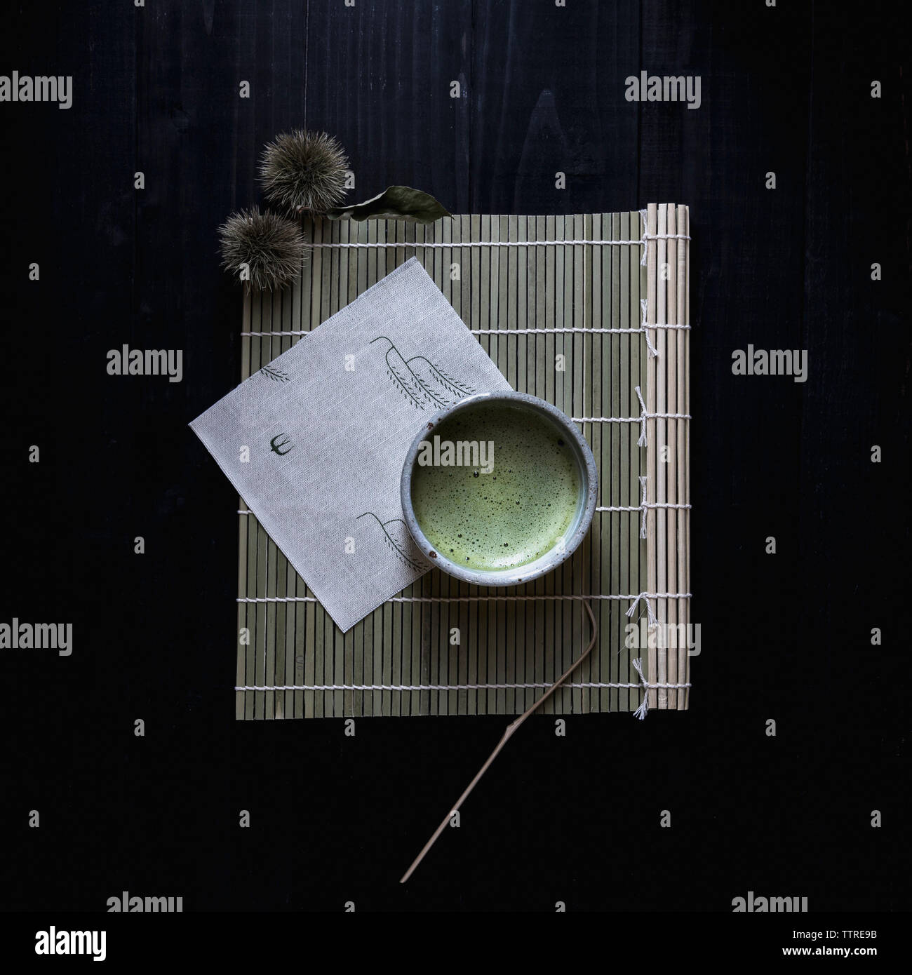 Overhead view of matcha tea in bowl on place mat Stock Photo