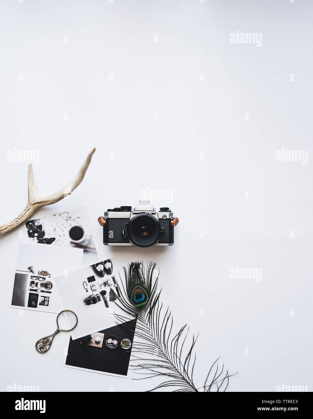 Overhead view of camera and photographs on white background Stock Photo