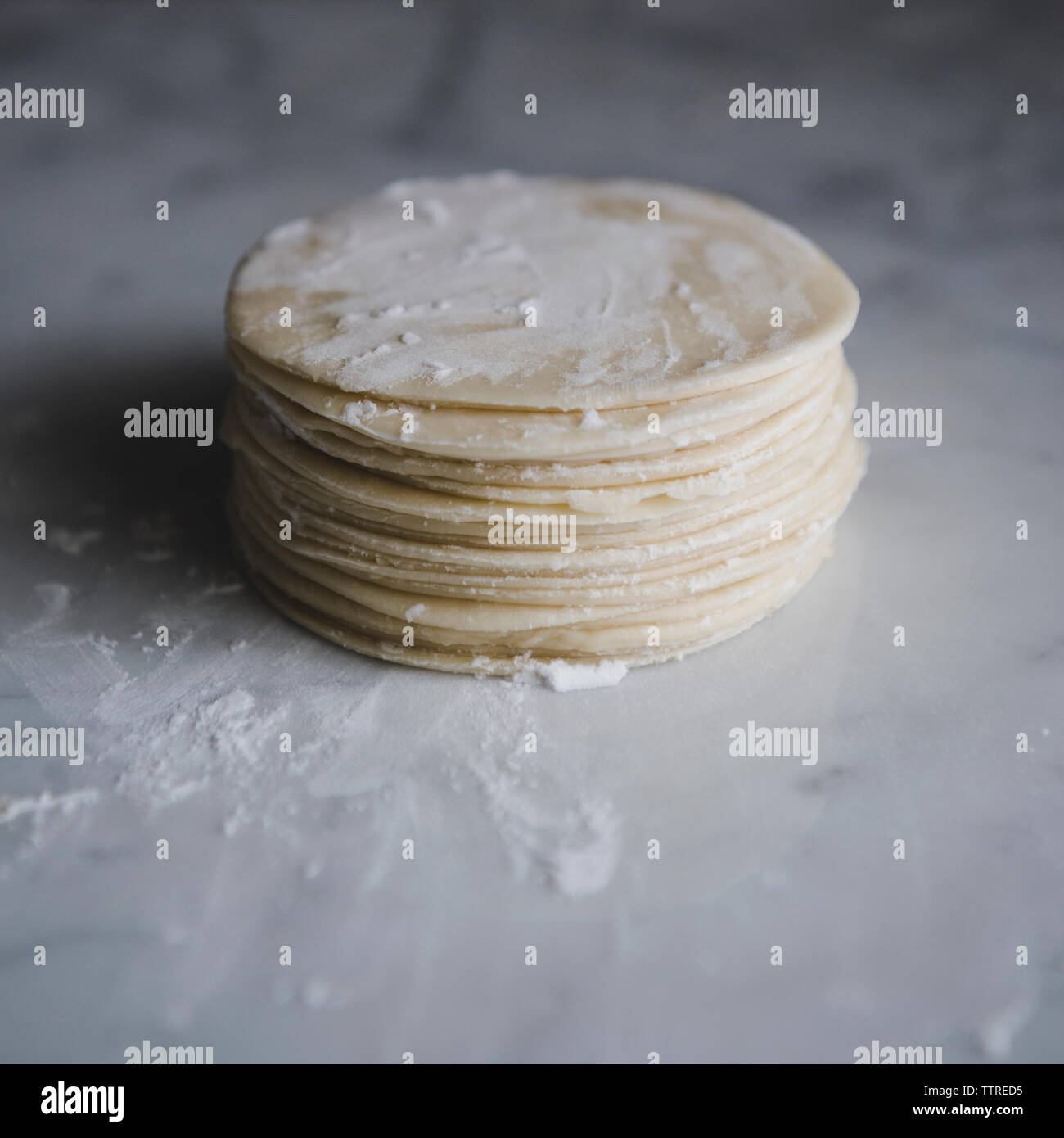 Stack of flat dough on kitchen counter Stock Photo