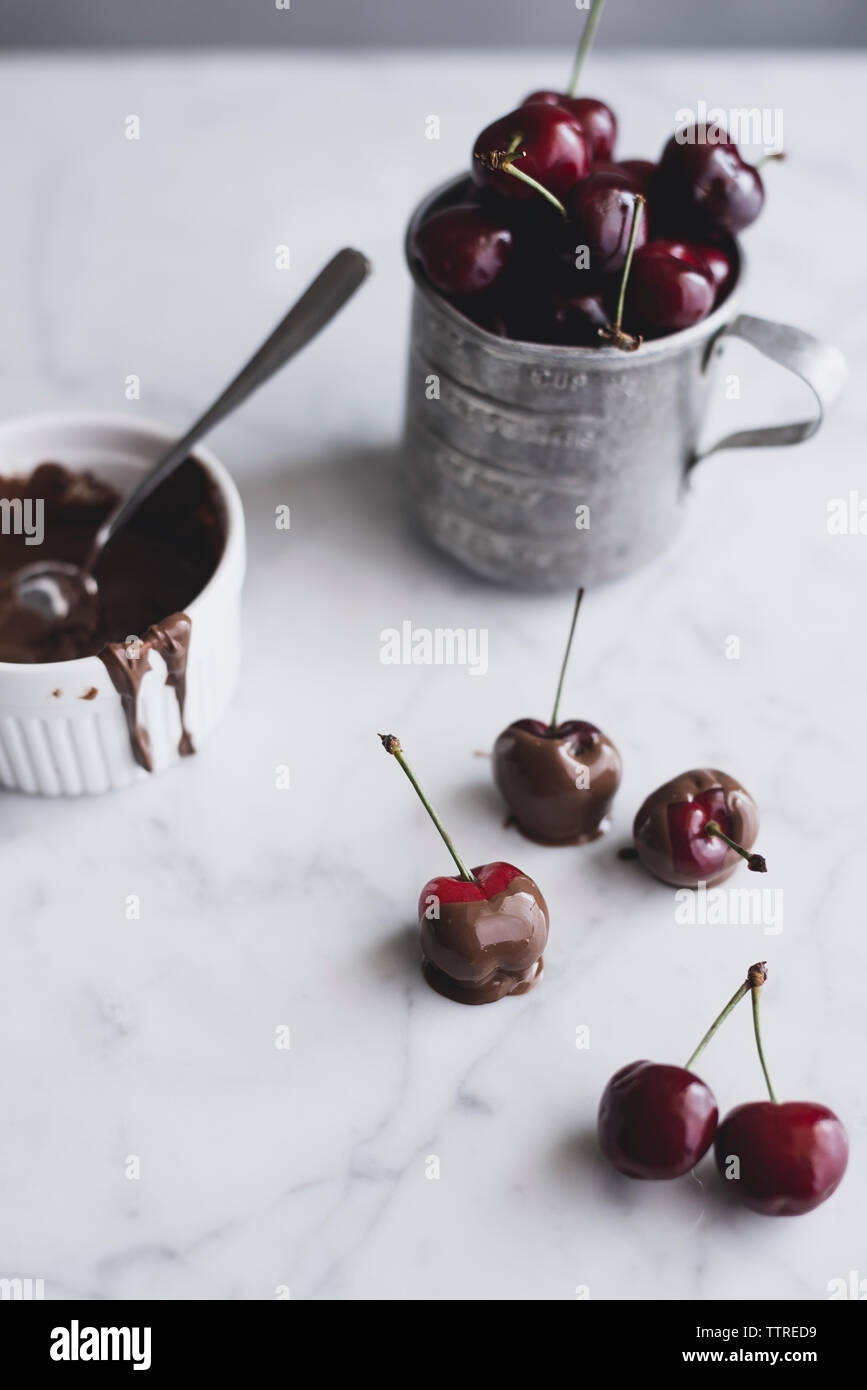 Cherries dipped in chocolate on table Stock Photo